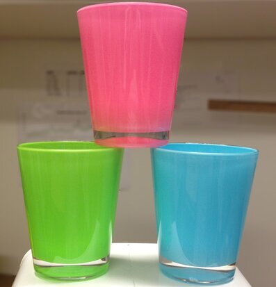 Bild av tre färgglada glas i grönt, blått och rosa