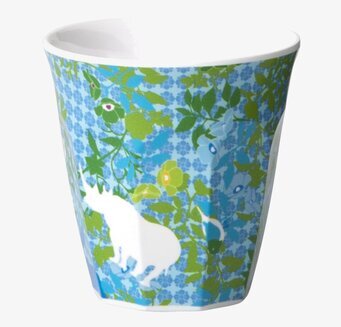 Foto av färgglad barnmugg med djurmotiv och grönska