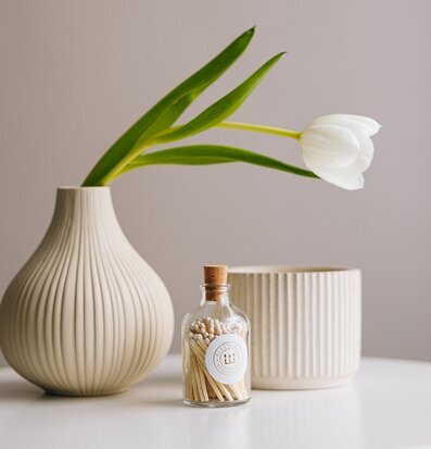 Foto av stilfullt arrangemang med tändstickor och vas