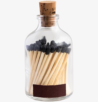 Bild av stilren glasburk med svarta tändstickor