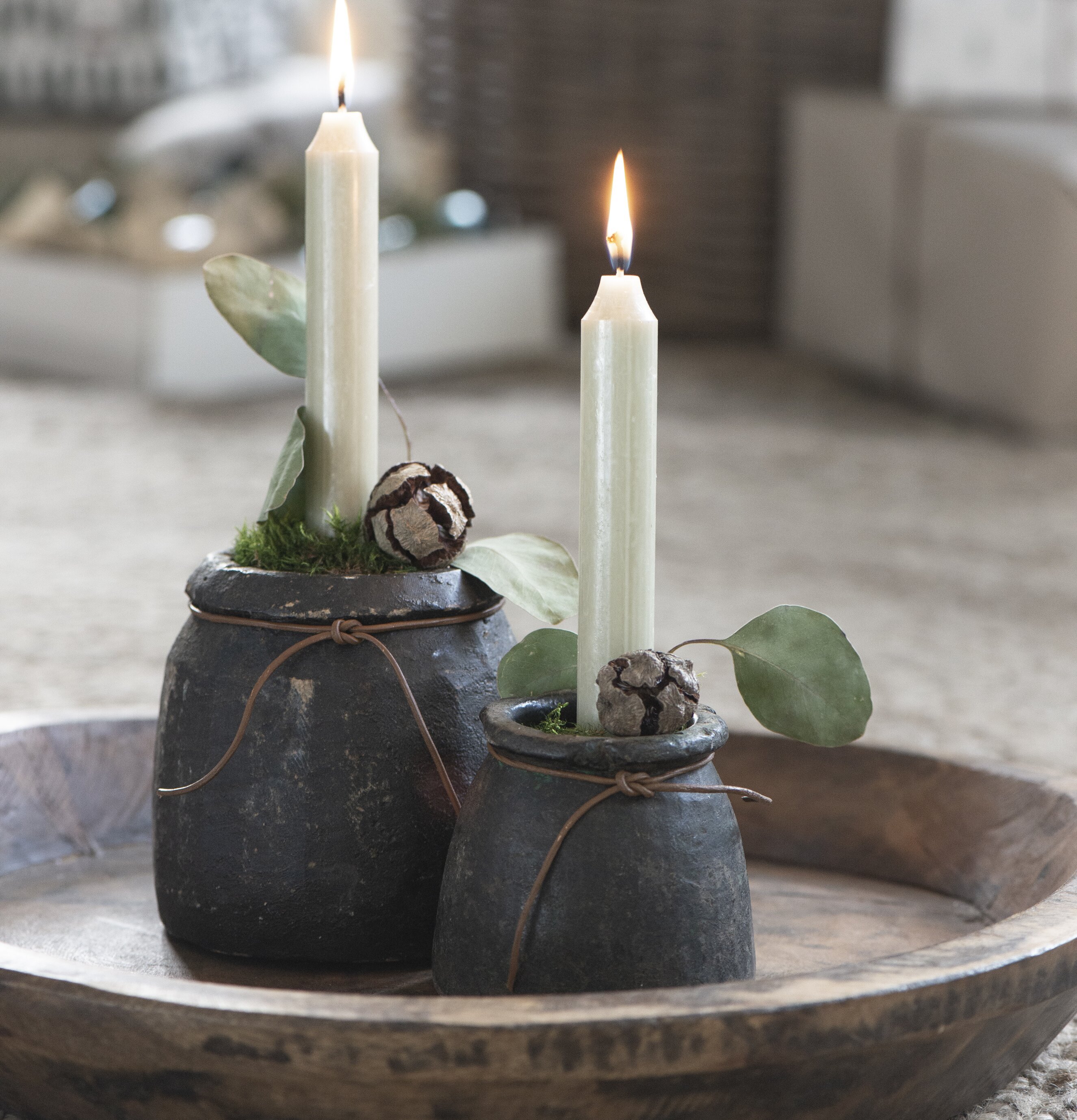 Bild av rustika stenkrukor med ljus och eukalyptus