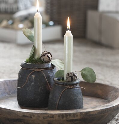 Bild av rustika stenkrukor med ljus och eukalyptus