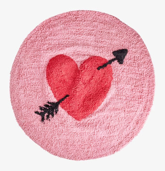 Bild av rund matta med rött hjärta och pil