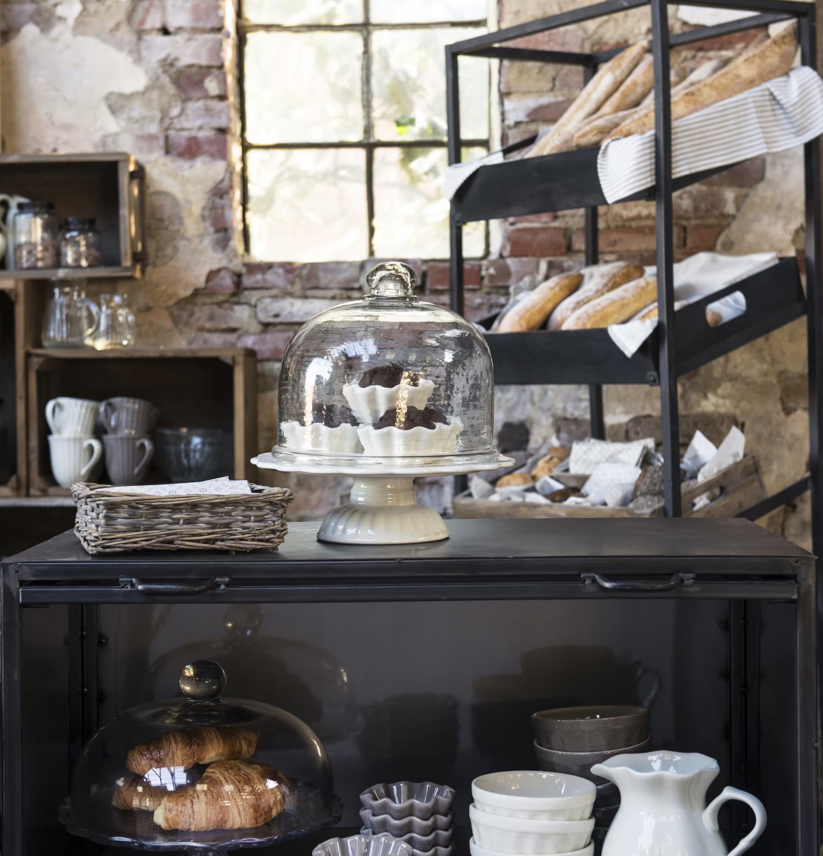 Foto av charmig butiksmiljö med glaskupa och bakverk
