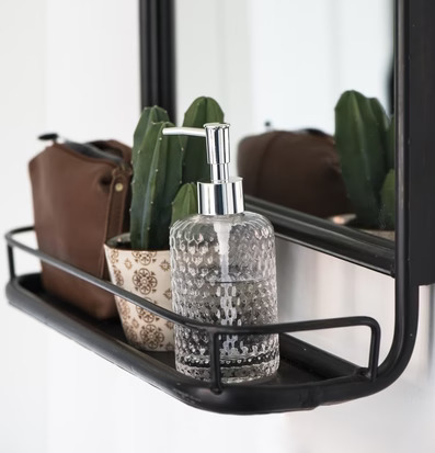 Foto av elegant tvålpump i glas med kaktus och necessär