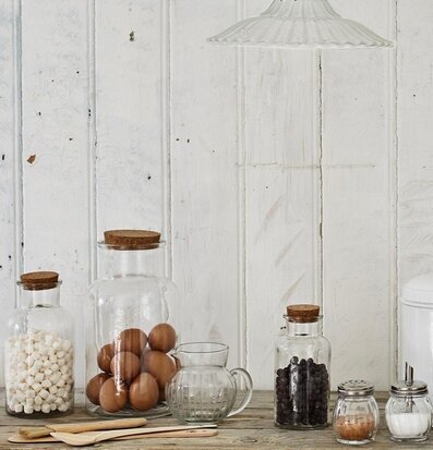 Foto av rustik köksmiljö med glasburkar och korklock