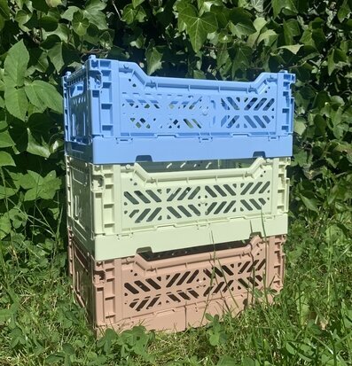 Foto av staplade plastbackar i solig utomhusmiljö