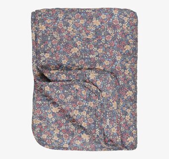 Bild av en quiltad pläd med blommönster och färgklick