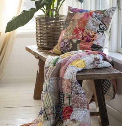 Bild av färgglad pläd och kudde i patchworkstil