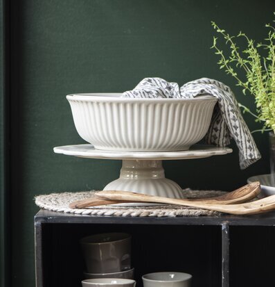 Foto av elegant dukning med tårtfat och växtarrangemang