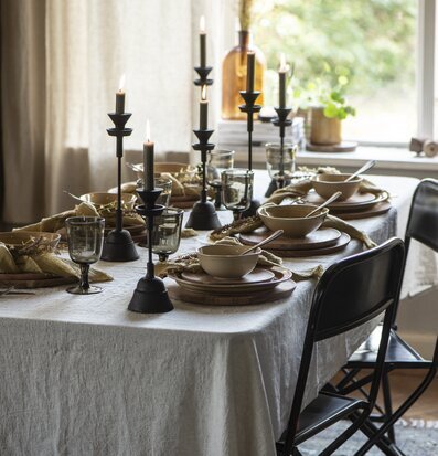Bild av smakfullt dukat bord med ljusstakar i järn