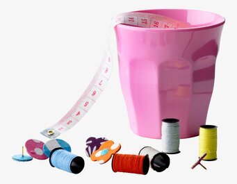 Bild av kreativt kaos med mugg och sybehörsdetaljer