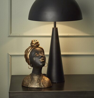 Bild av elegant inredning med byst och bordslampa