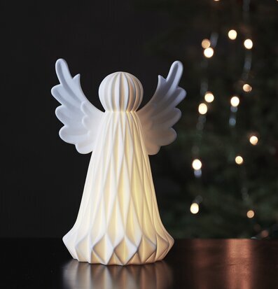 Bild av stilren ängel som lyser upp vintermörkret