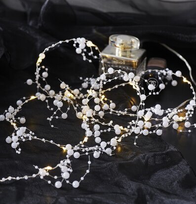 Bild av ljusslinga med pärlor mot mörk bakgrund