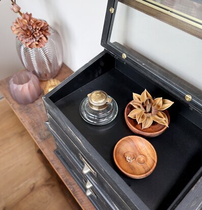 Bild av elegant byrå med glaslock och mässingsdetaljer