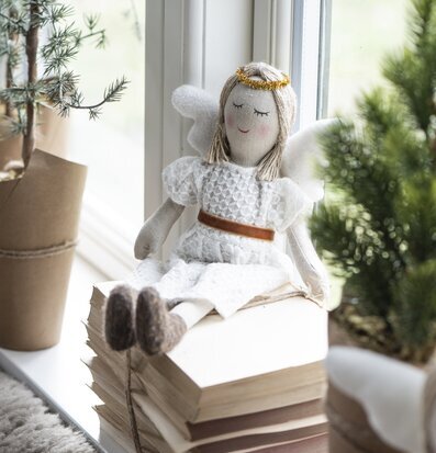 Bild av en ängel på böcker med juldekorationer