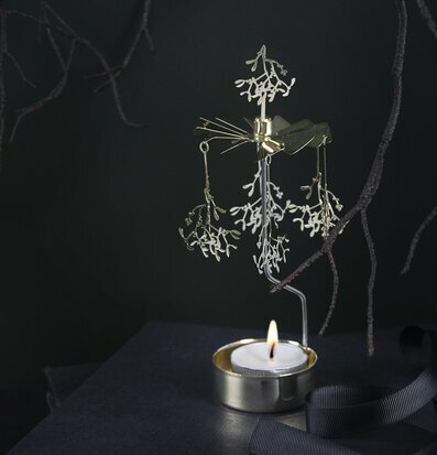 Foto av ett gyllene änglaspel med värmeljusreflektioner