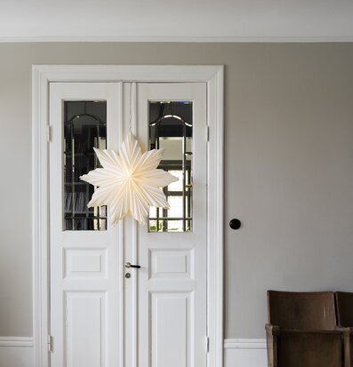 Bild av elegant vardagsrum med julstjärna och fåtölj