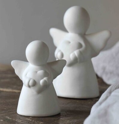 Bild av vita änglafigurer på rustik träyta