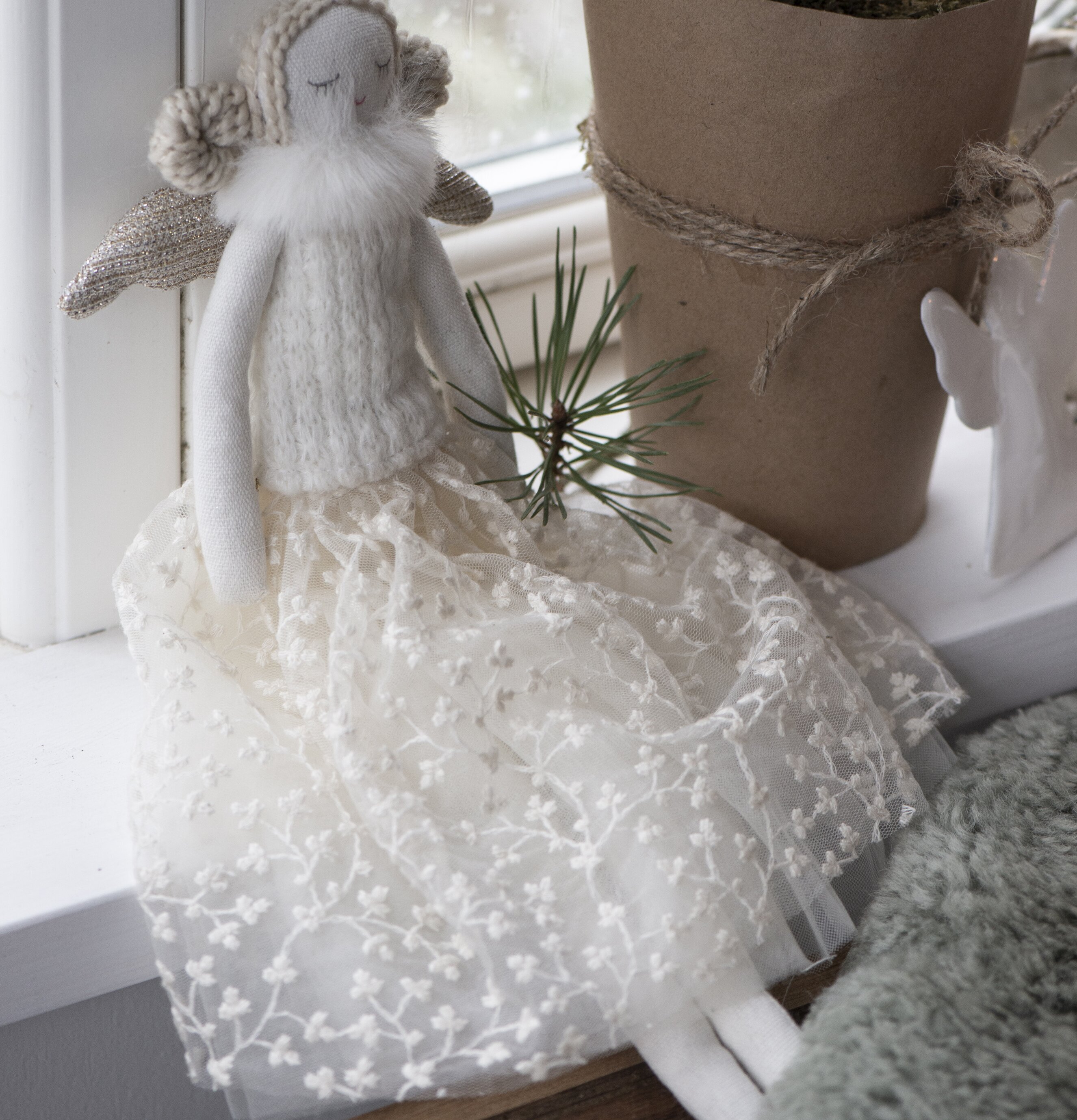 Bild av en ängel i fönster med krukväxt och regn