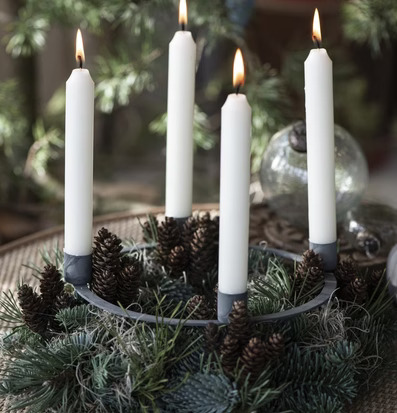 Foto av adventsljusstake med vintergrönt och ljus