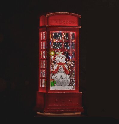 Bild av röd telefonkiosk med snögubbe och LED-ljus