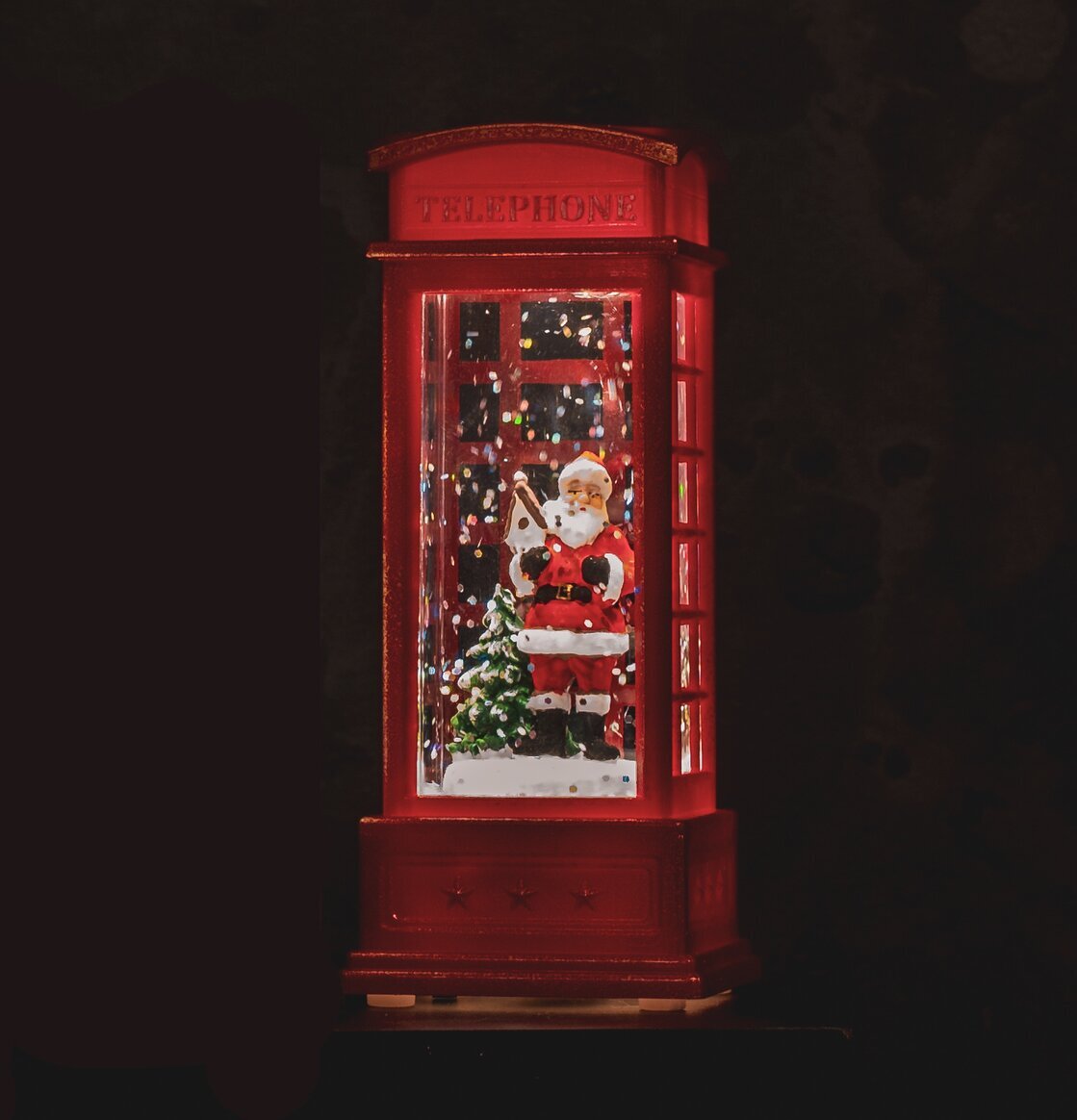 Bild av festlig telefonkiosk med tomte och LED-ljus