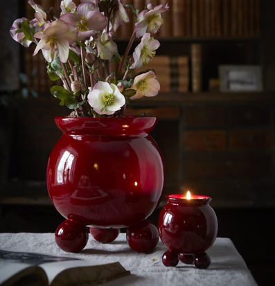 Bild av elegant inredning med röd kruka och ljusstake