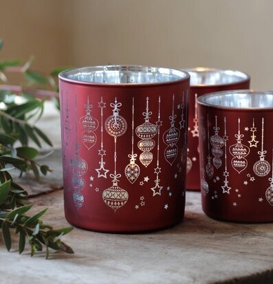 Bild av röd-silverfärgade ljuslyktor i hemtrevlig miljö