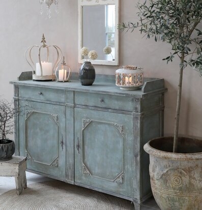 Bild av harmoniskt inrett rum med antik grön byrå