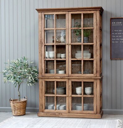 Bild av inbjudande interiör med vitrinskåp och växt