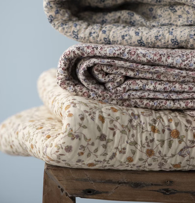 Foto av tre vikta täcken på rustik trästol