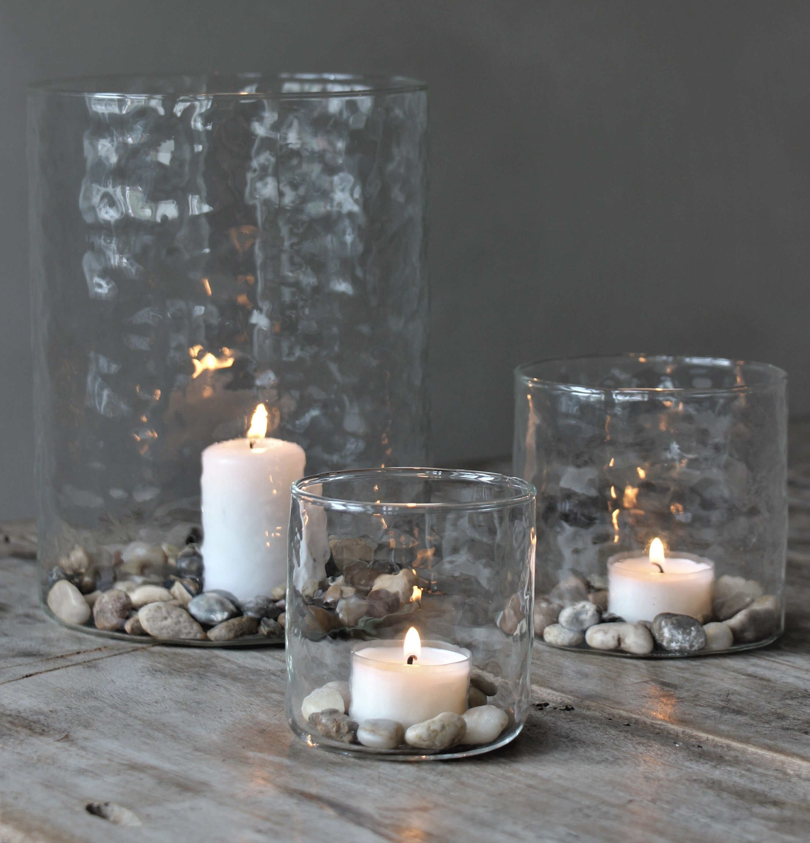 Bild av ljuslyktor på rustik träyta med stenar