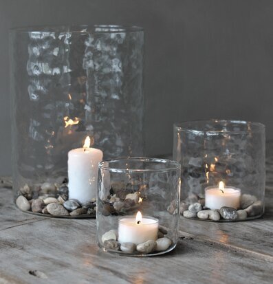 Bild av ljuslyktor på rustik träyta med stenar