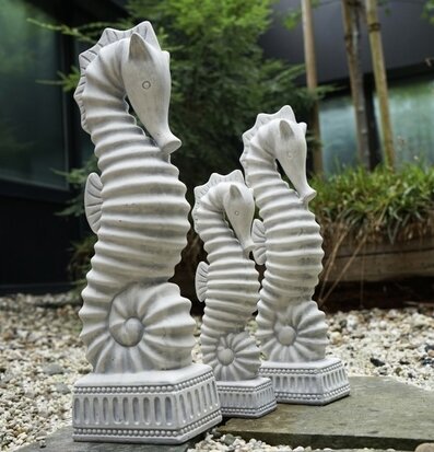 Bild av tre vita sjöhästskulpturer i keramik