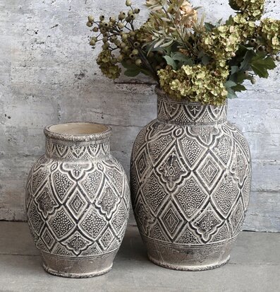 Bild av rustik vas mot betongvägg med torkade blommor