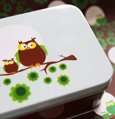 Bild av stiliserade ugglor på en färgglad mellanbox