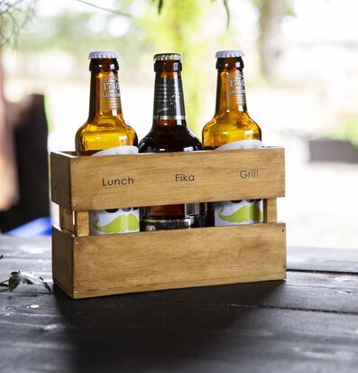 Foto av stilren trälåda med flaskor och rustik känsla