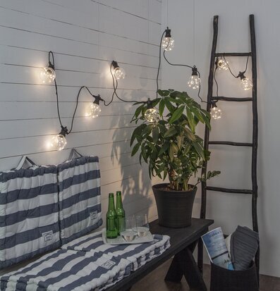 Bild av harmonisk inredning med ljusslinga och växt