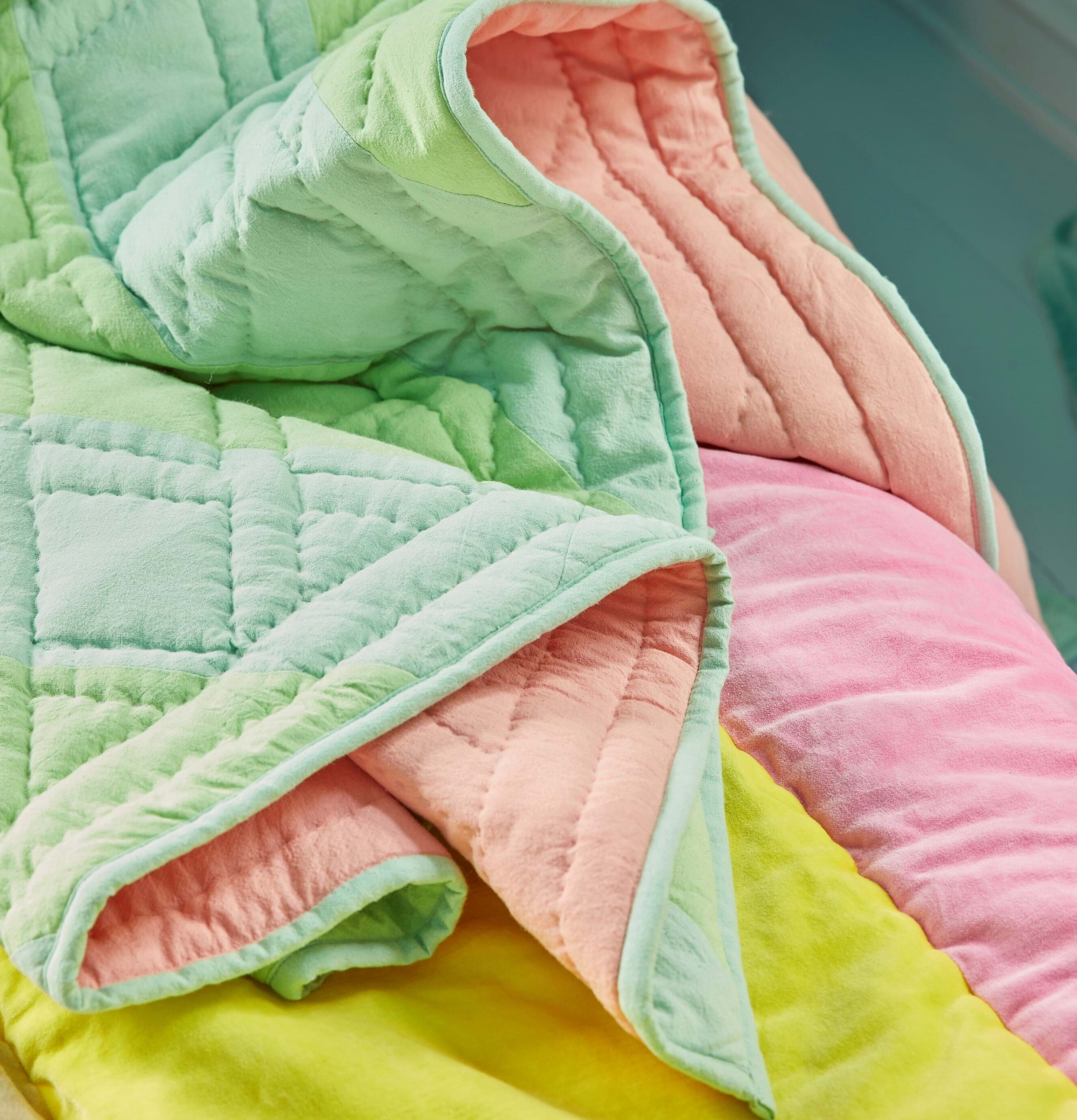 Bomullsfilt Green & Blue Stripes från Rice på en säng