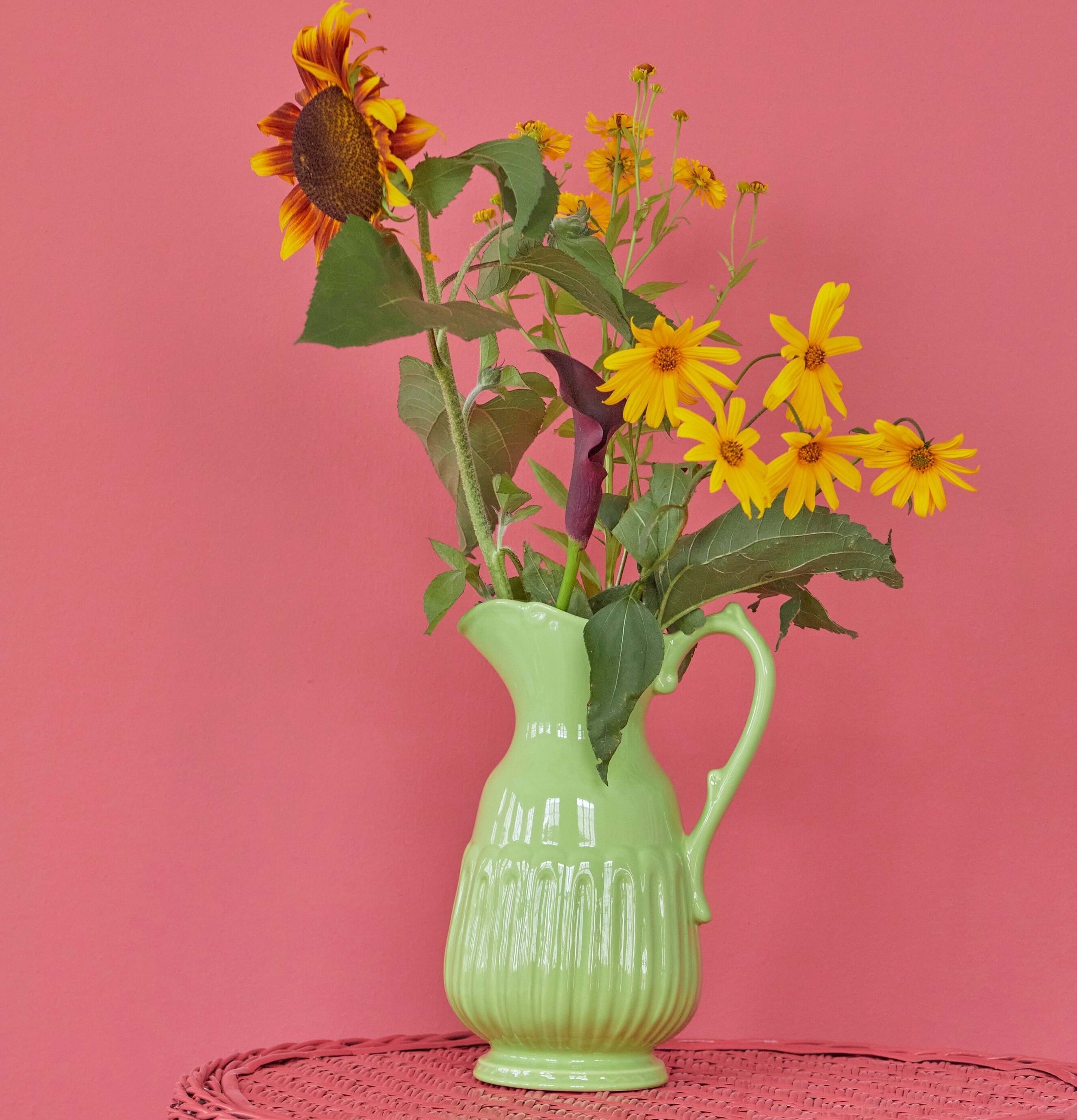 Foto av elegant keramik-kanna med blommor i fokus