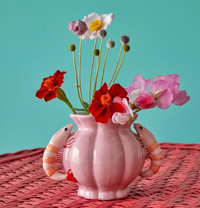 Bild av keramikvas med räkor och färgglada blommor