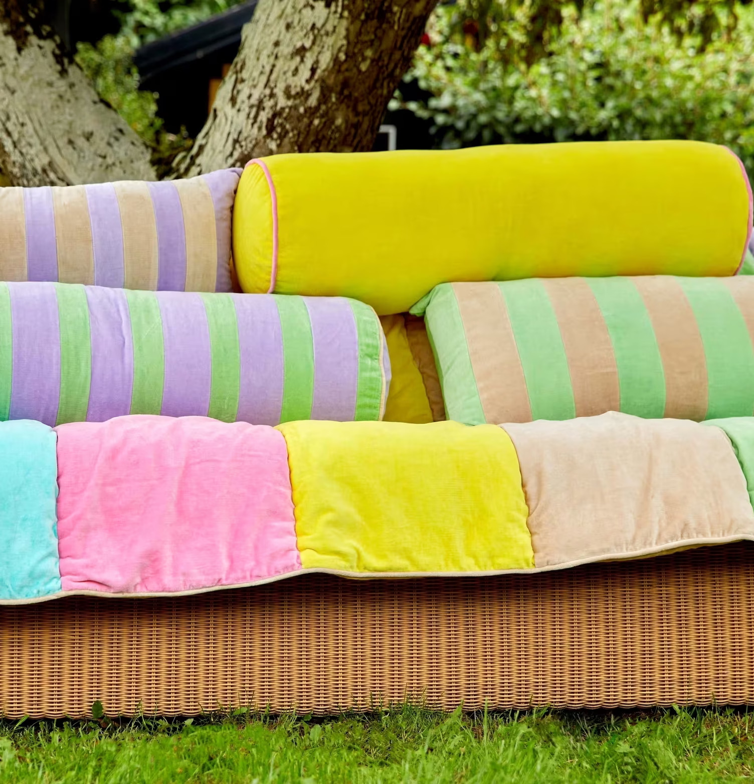 Bild av färgglada prydnadskuddar på rottingsoffa