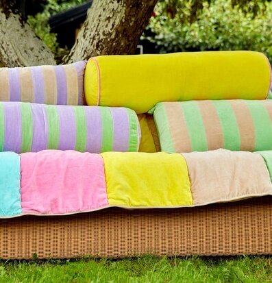Bild av färgglada prydnadskuddar på rottingsoffa