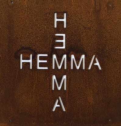 Bild av rustik skylt med ordet HEMMA i korsmönster