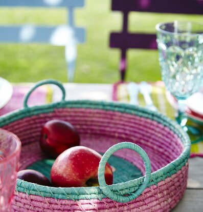 Bild av färgglad brödkorg med frukt och trädgårdsbakgrund