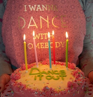 Bild av festlig tårta med färgglada ljus och dekorationer