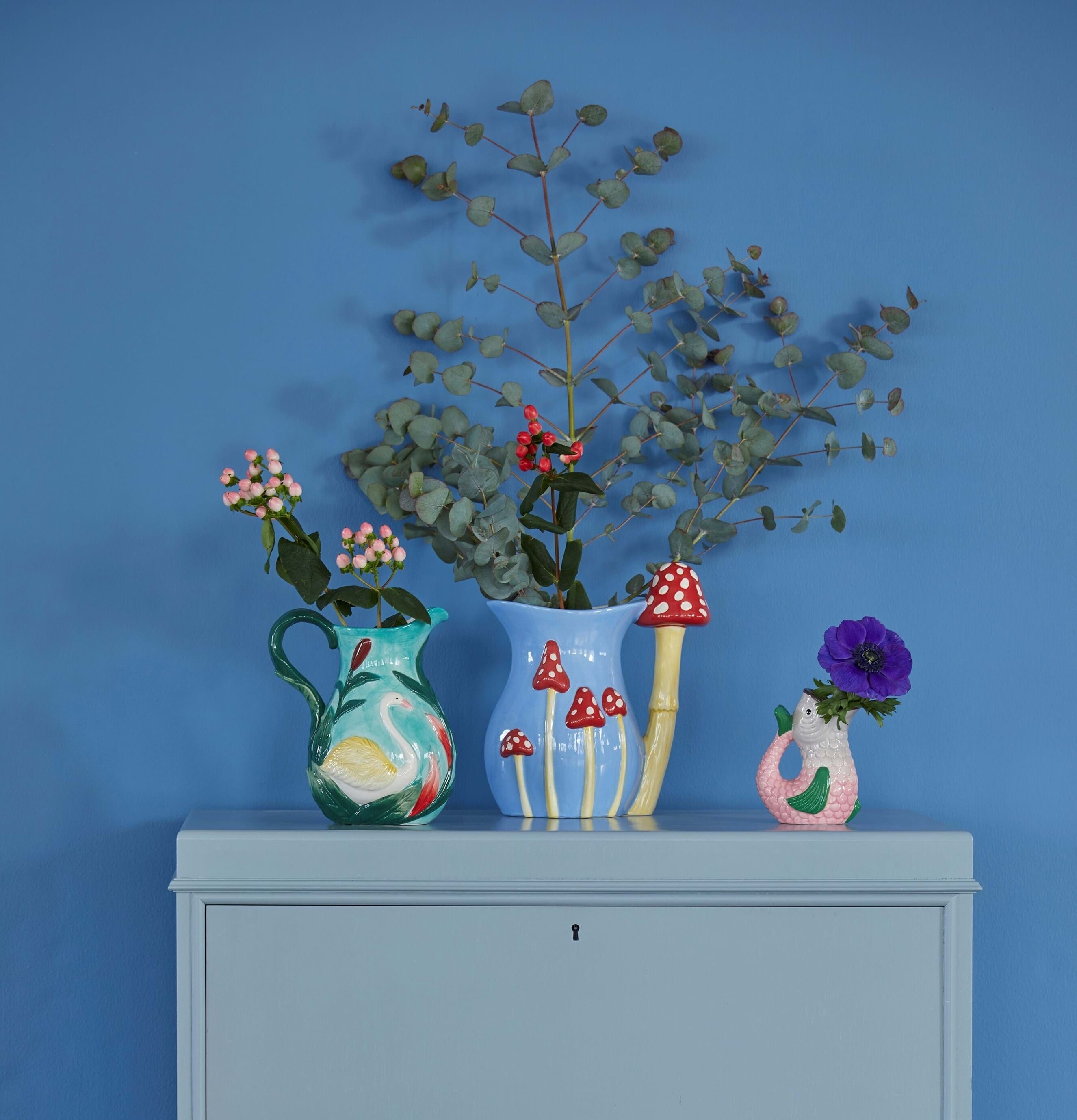 Vas Fish Shape från Rice på blålackerad möbel med blommor