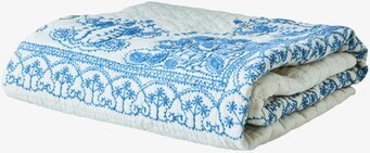 Foto av ett elegant broderat överkast i vitt och blått